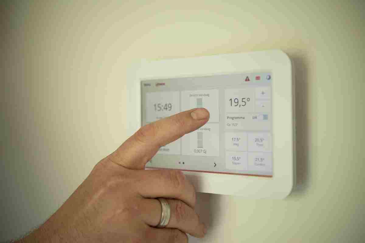 Ce este un termostat pentru centrala si cum functioneaza_Persoana setand temperatura la termostatul smart de perete