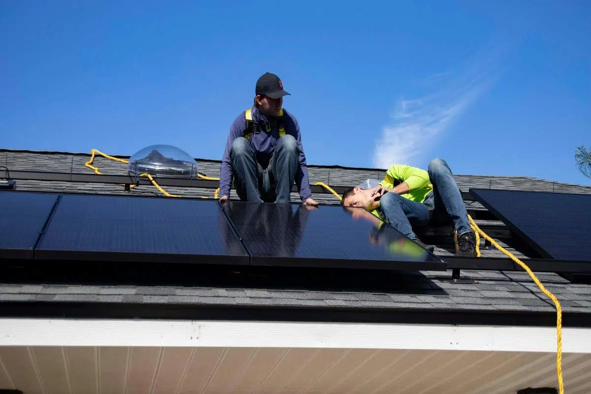 Cate panouri fotovoltaice sunt necesare pentru o casa_Afla pas cu pas_Persoane care monteaza panouri fotovoltaice pe acoperis, casa, cer senin - romstal.ro