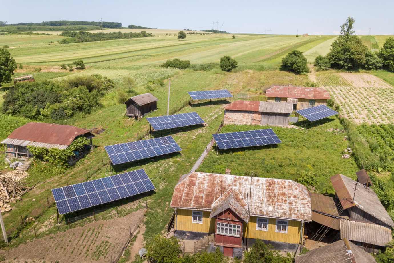 Cele mai recomandate sisteme fotovoltaice hibride (fotografie aeriana cu o gospodarie de la tara, zona de campie, sisteme fotovoltaice)